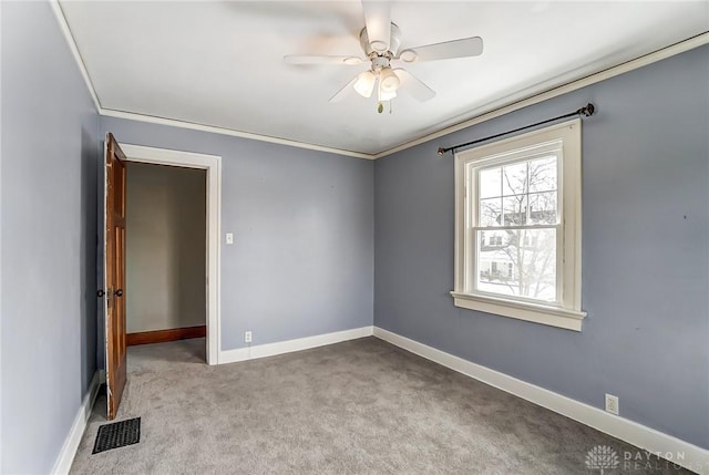 spare room with visible vents, crown molding, light carpet, and baseboards