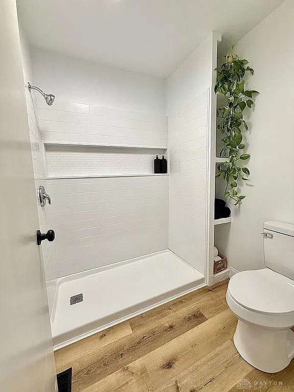 bathroom with walk in shower, wood-type flooring, and toilet