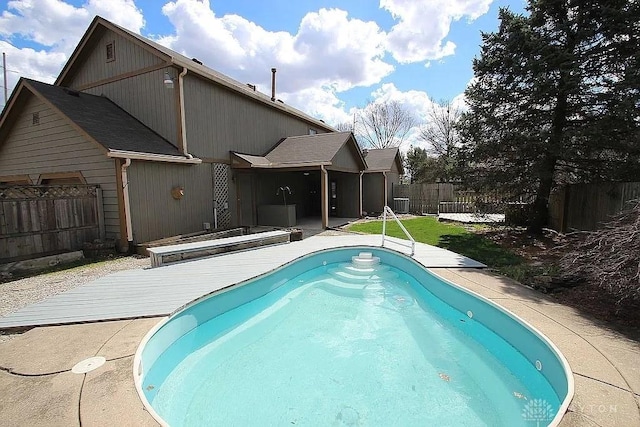 view of swimming pool featuring a fenced backyard and a deck