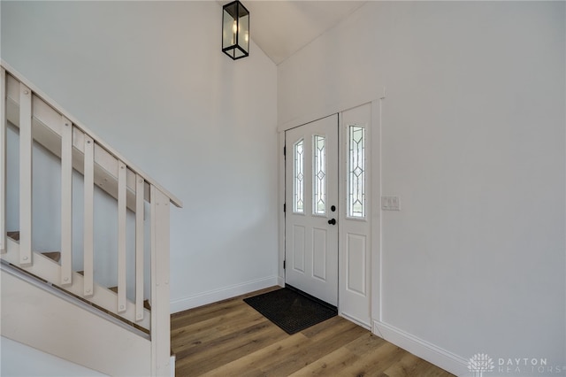 foyer entrance with a high ceiling, wood finished floors, and baseboards