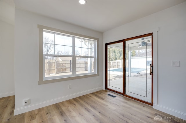 doorway to outside featuring light wood finished floors, visible vents, and baseboards