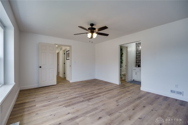 spare room featuring light wood-type flooring, baseboards, visible vents, and a ceiling fan