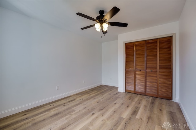 unfurnished bedroom featuring a closet, baseboards, ceiling fan, and light wood finished floors