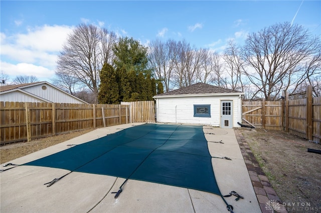 view of swimming pool featuring a patio area, a fenced backyard, and an outdoor structure