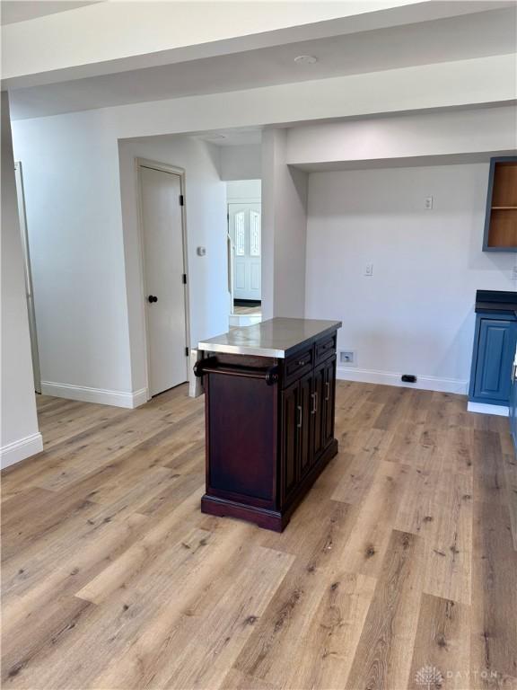 545 E Whipp Rd, Dayton, OH 45459 - kitchen featuring light wood-style floors, baseboards, a center island, and dark brown cabinets
