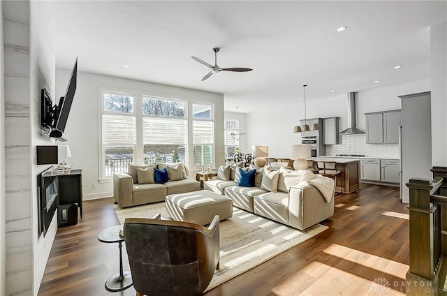 living room featuring ceiling fan and dark hardwood / wood-style flooring