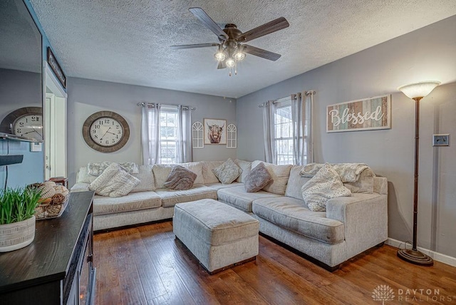 living room with ceiling fan, dark hardwood / wood-style floors, and a textured ceiling