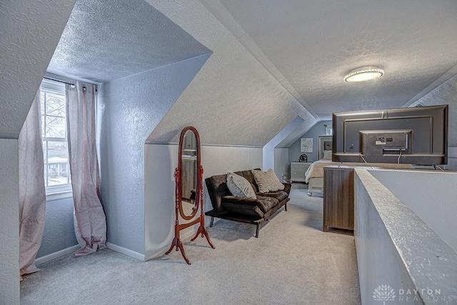 carpeted bedroom with vaulted ceiling and a textured ceiling