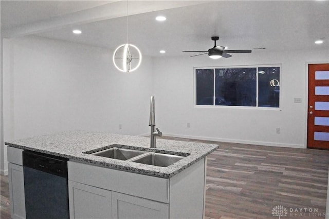 kitchen featuring white cabinetry, sink, stainless steel dishwasher, and light stone countertops