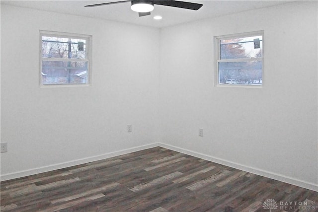 spare room with dark wood-type flooring and ceiling fan