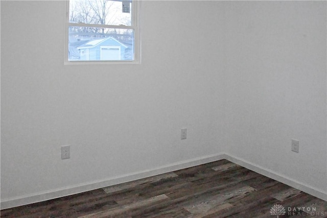 empty room with dark hardwood / wood-style flooring