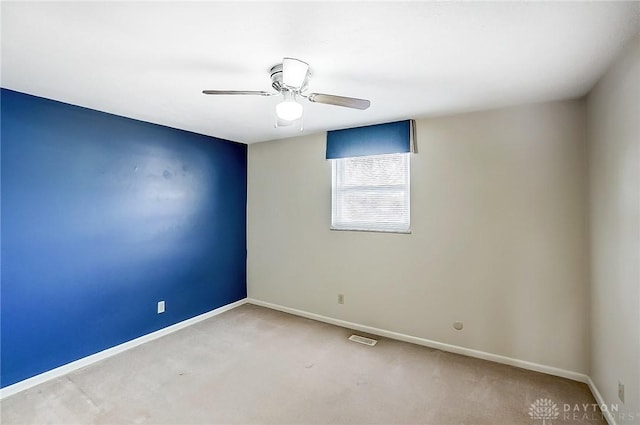 carpeted spare room featuring ceiling fan