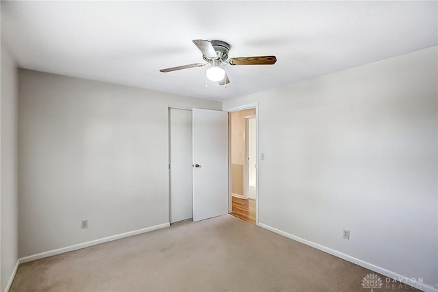 carpeted spare room featuring ceiling fan