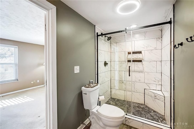 bathroom featuring toilet and a shower with door