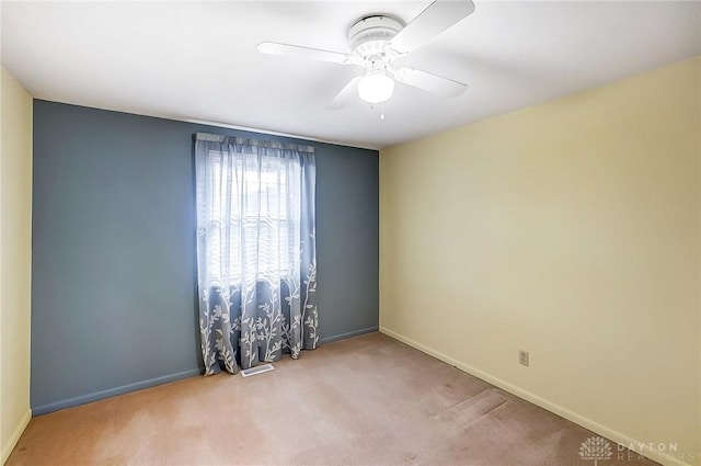 unfurnished room with ceiling fan and light carpet