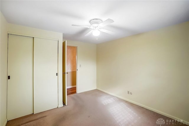 unfurnished bedroom with ceiling fan, carpet, and a closet