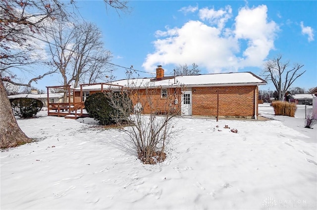 view of snow covered back of property