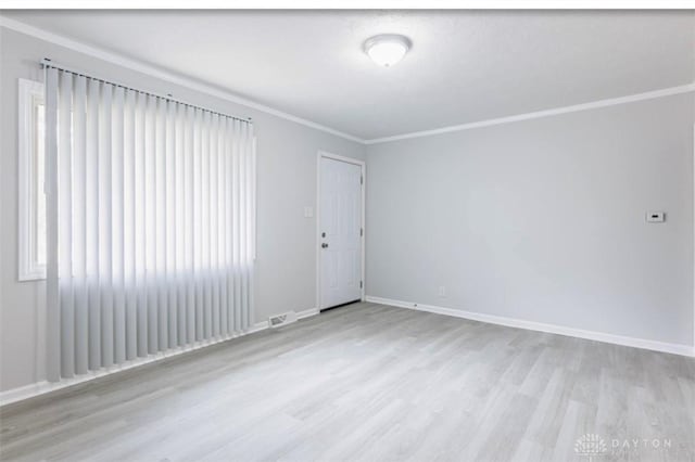 unfurnished room with crown molding and light hardwood / wood-style flooring