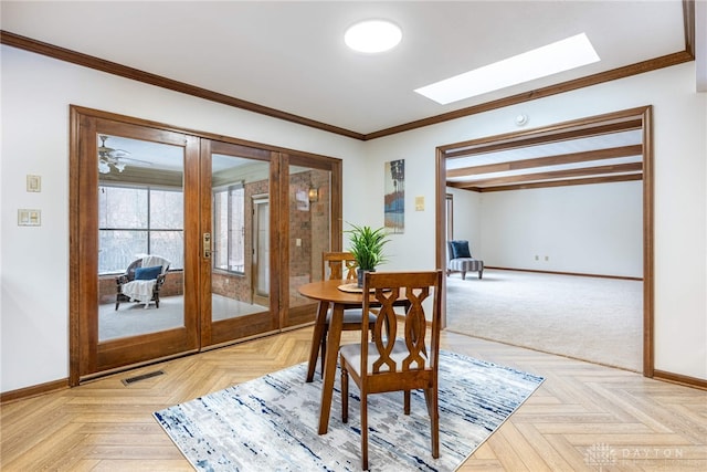 dining area with french doors, crown molding, a skylight, and light parquet floors