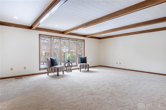 unfurnished room featuring beamed ceiling and carpet floors