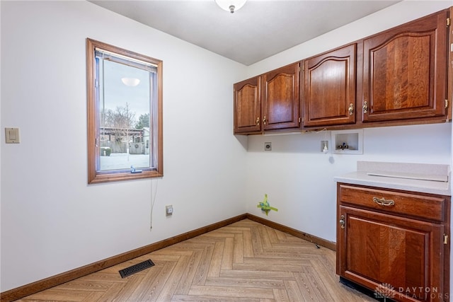 washroom featuring cabinets, hookup for an electric dryer, light parquet floors, and washer hookup