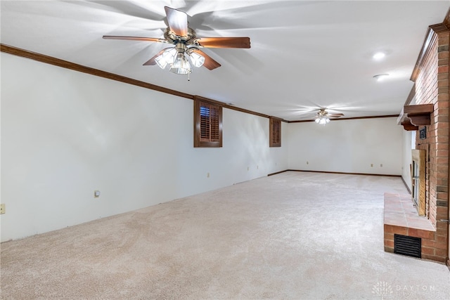 unfurnished living room featuring crown molding, a brick fireplace, and light colored carpet