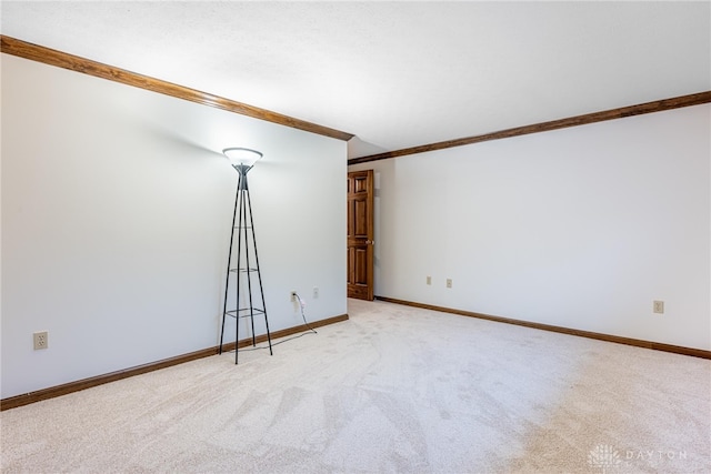 carpeted empty room featuring crown molding