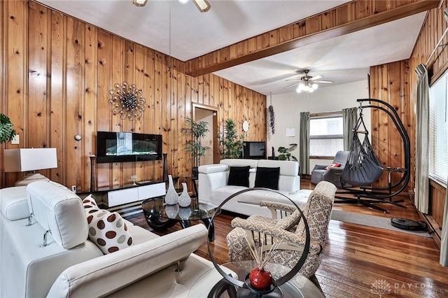 living room featuring hardwood / wood-style floors, wooden walls, beamed ceiling, and ceiling fan