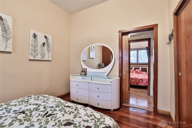 bedroom with dark hardwood / wood-style flooring and a closet