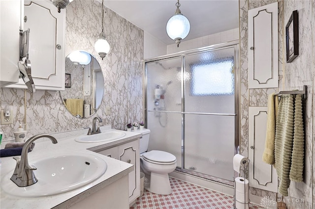 bathroom featuring vanity, toilet, and a shower with door