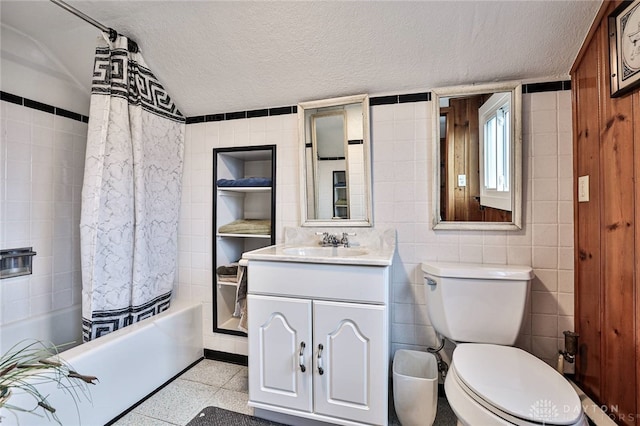 full bathroom with vanity, shower / bath combo, tile walls, and a textured ceiling