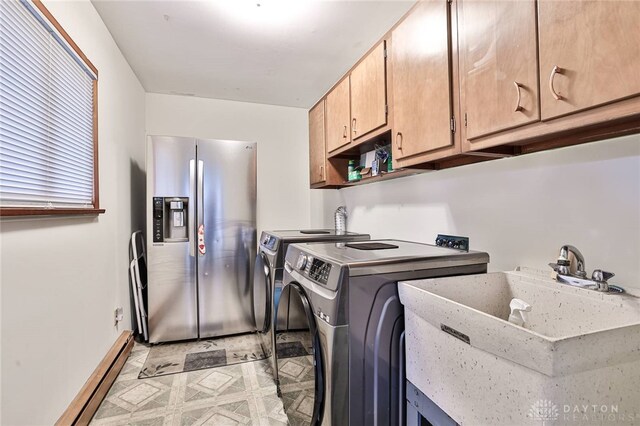 laundry area with cabinets, sink, washing machine and dryer, and a baseboard heating unit