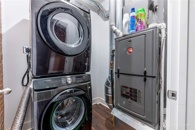 laundry room featuring dark wood-type flooring and stacked washing maching and dryer