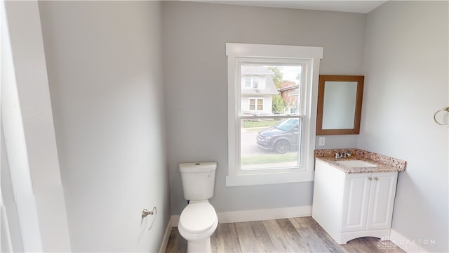 bathroom with hardwood / wood-style flooring, vanity, and toilet