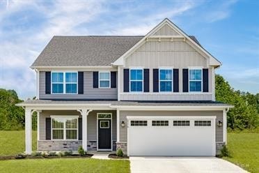 craftsman house with a garage, a porch, and a front yard