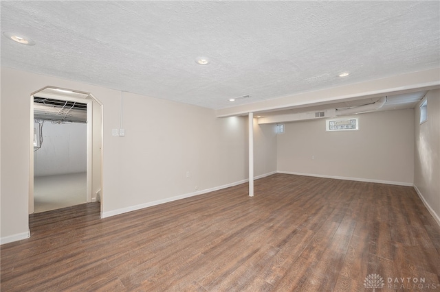 basement with dark wood-type flooring and a textured ceiling