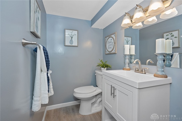 bathroom featuring vanity, wood-type flooring, and toilet