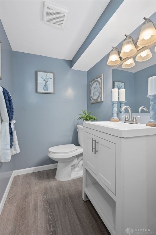 bathroom featuring vanity, hardwood / wood-style floors, and toilet