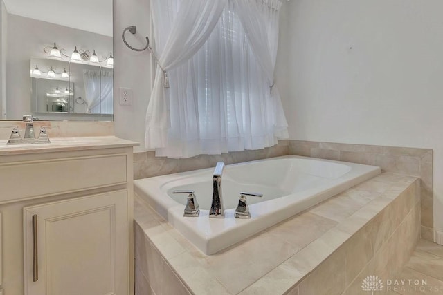 bathroom with vanity and tiled bath