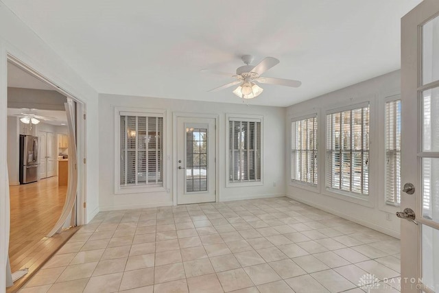 unfurnished sunroom with ceiling fan