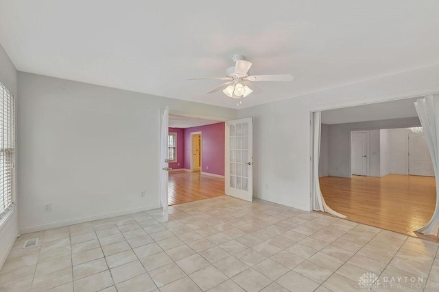 tiled spare room with french doors, ceiling fan, and a healthy amount of sunlight