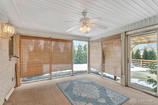 unfurnished sunroom featuring ceiling fan