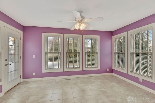 unfurnished sunroom featuring ceiling fan