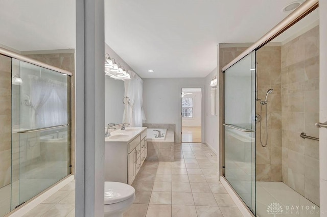 full bathroom featuring shower with separate bathtub, toilet, tile patterned floors, and vanity