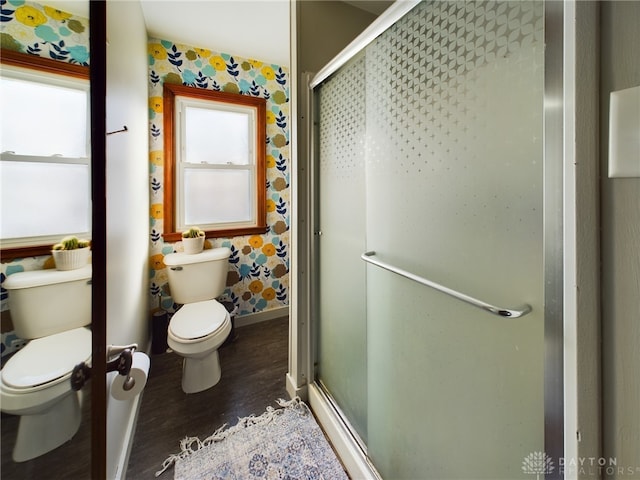 bathroom featuring hardwood / wood-style floors, an enclosed shower, and toilet