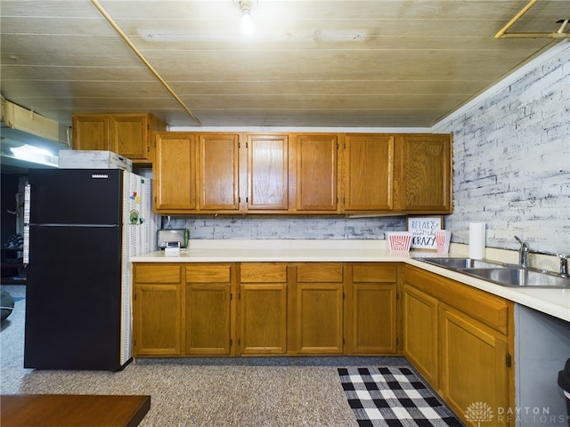 kitchen with black fridge, brick wall, sink, and wooden ceiling