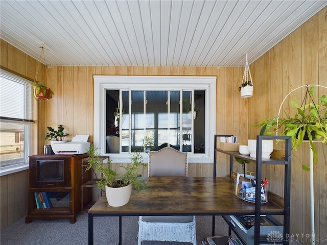 carpeted office featuring wood walls