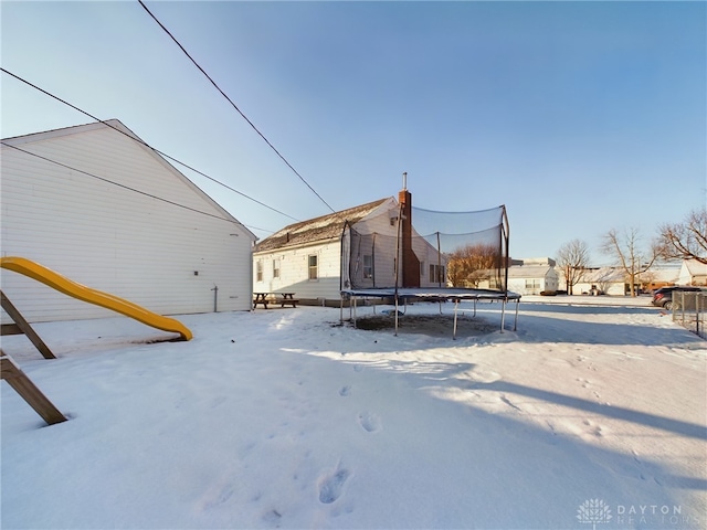 yard covered in snow featuring a trampoline