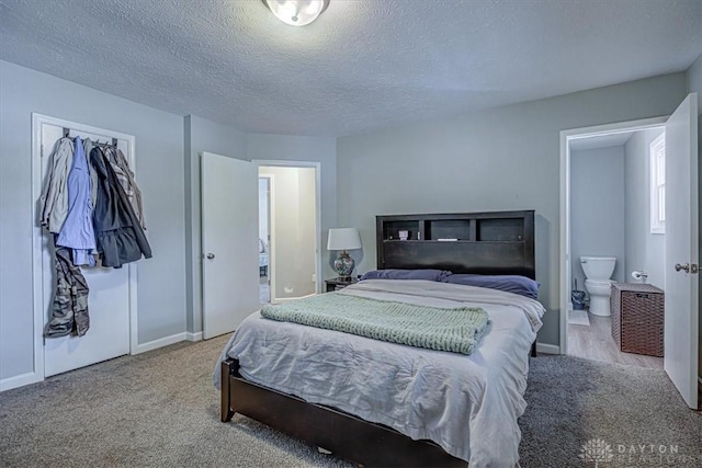 bedroom with light carpet, connected bathroom, and a textured ceiling