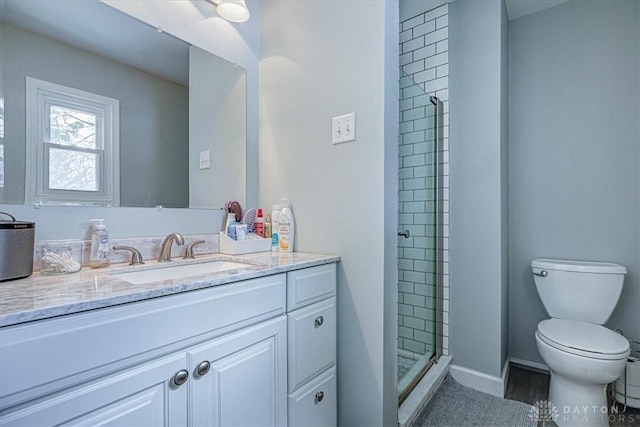 bathroom featuring vanity, toilet, and a shower with shower door